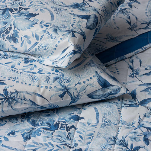 Dettaglio coppia di federe, lenzuolo e copriletto con elegante stampa ornamentale blu