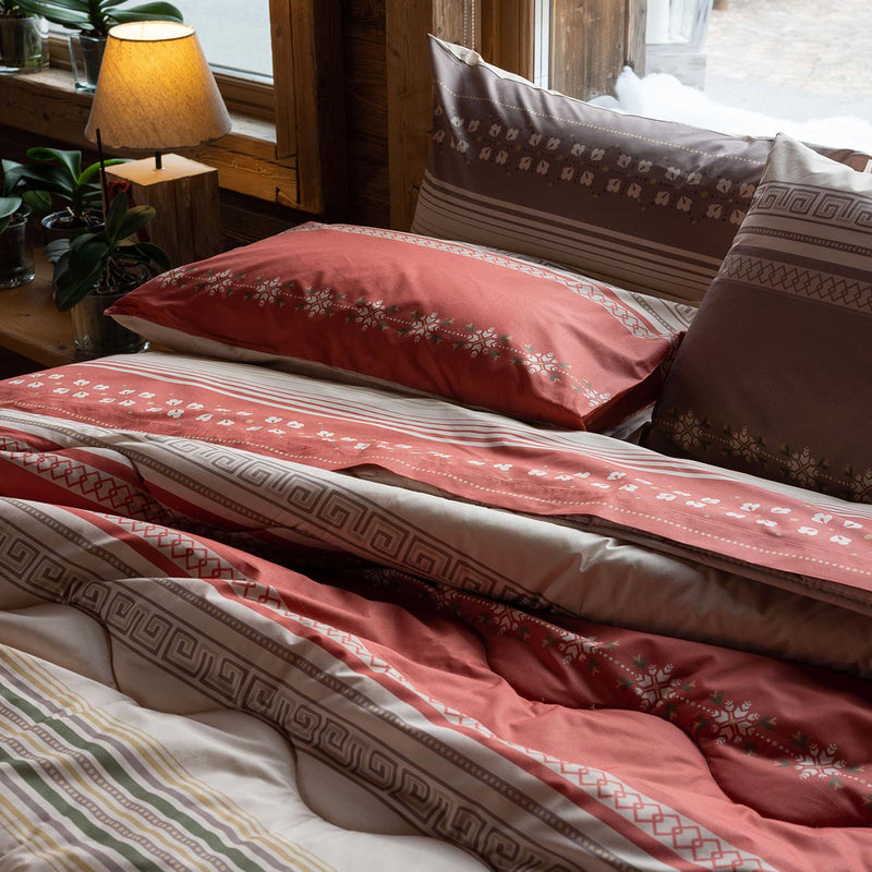 Una completo letto in percalle di cotone con motivi geometrici tirolesi, nei caldi colori che rimandano subito ai boschi. paola marella matrimoniale