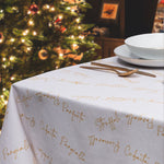 dettaglio della tovaglia in cotone anti macchia con scritte in oro su fondo bianco di dolci natalizi