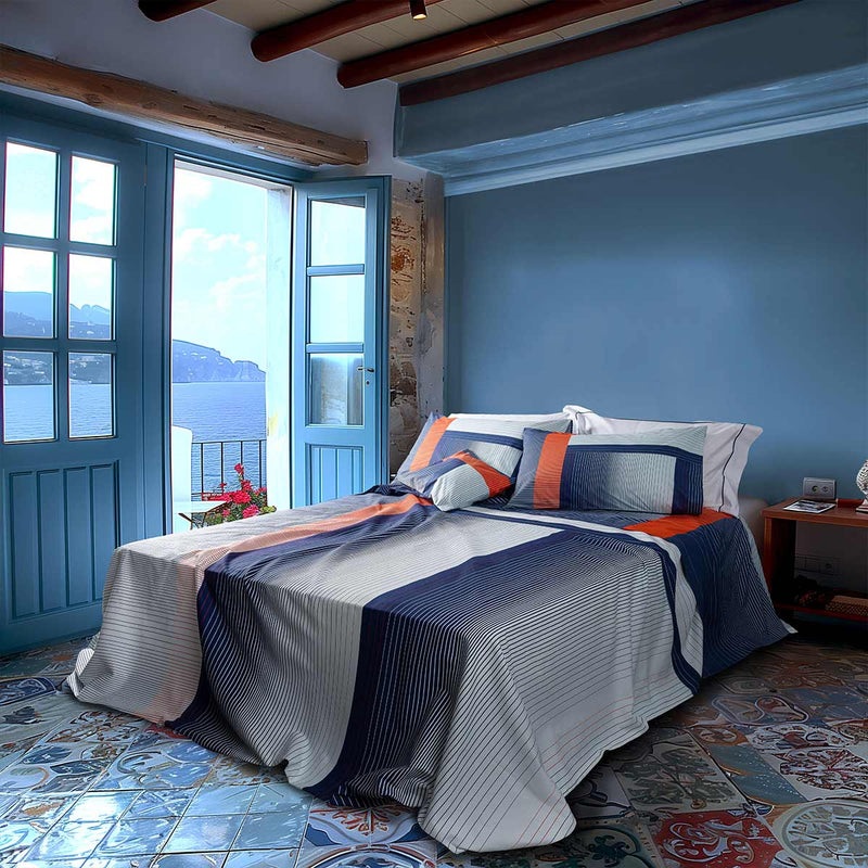 Parure letto marinaro in percalle di cotone con stampa a righe alternate e sfumate dai colori vivaci rosso, blu e bianco Casa al mare Paola Marella